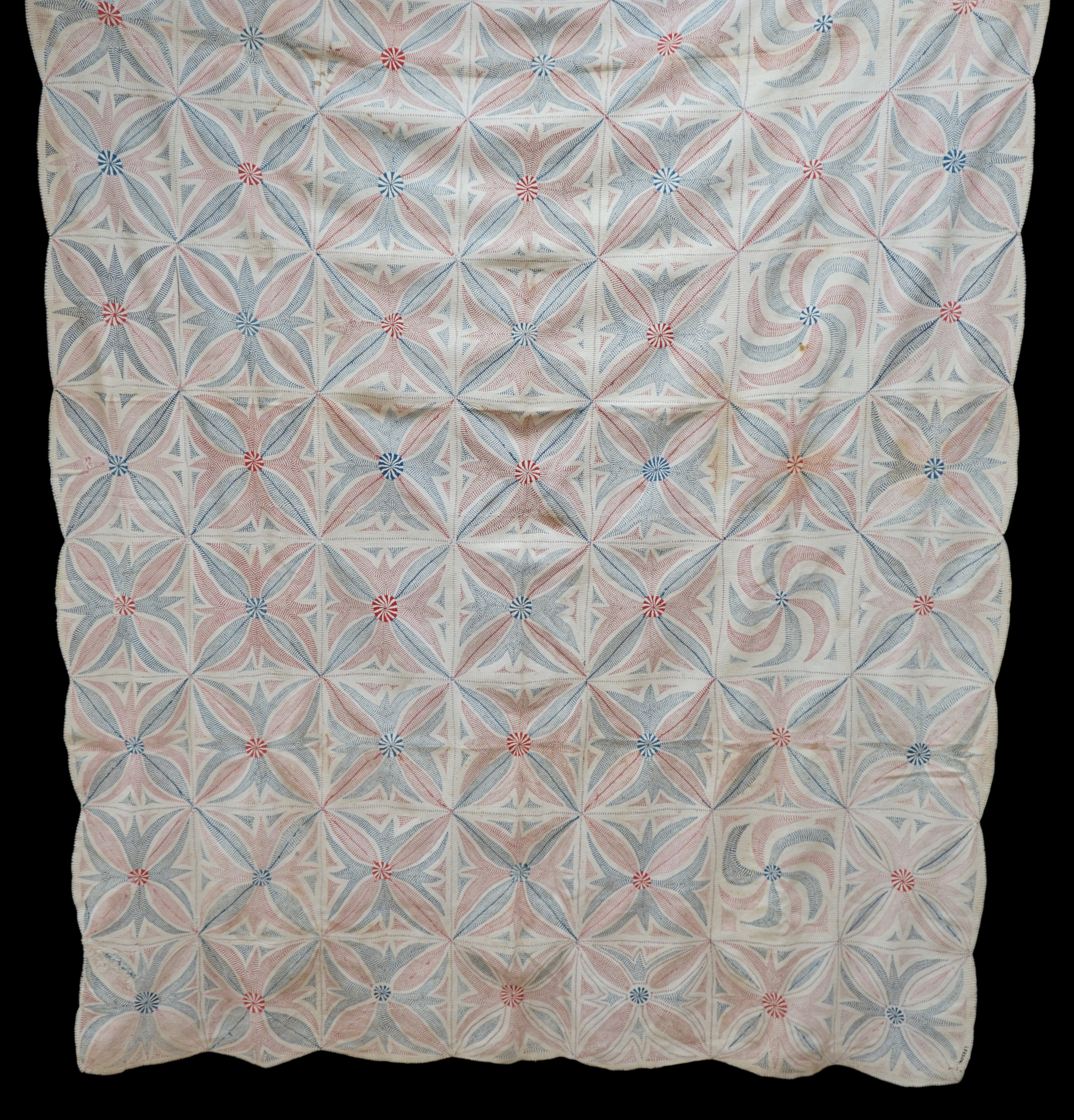 An early 20th century West Bengal Kantha embroidered quilt, embroidered on cream cloth (possibly made from layers of old saris) embroidered in blue and red threads, designed in squares of large abstracted floral motifs u